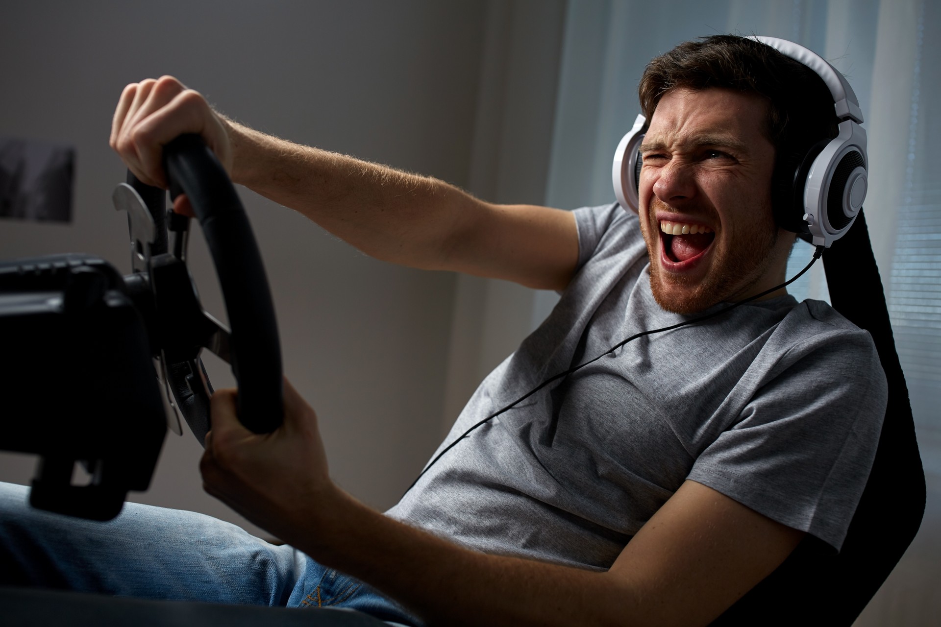 man playing car racing video game at home