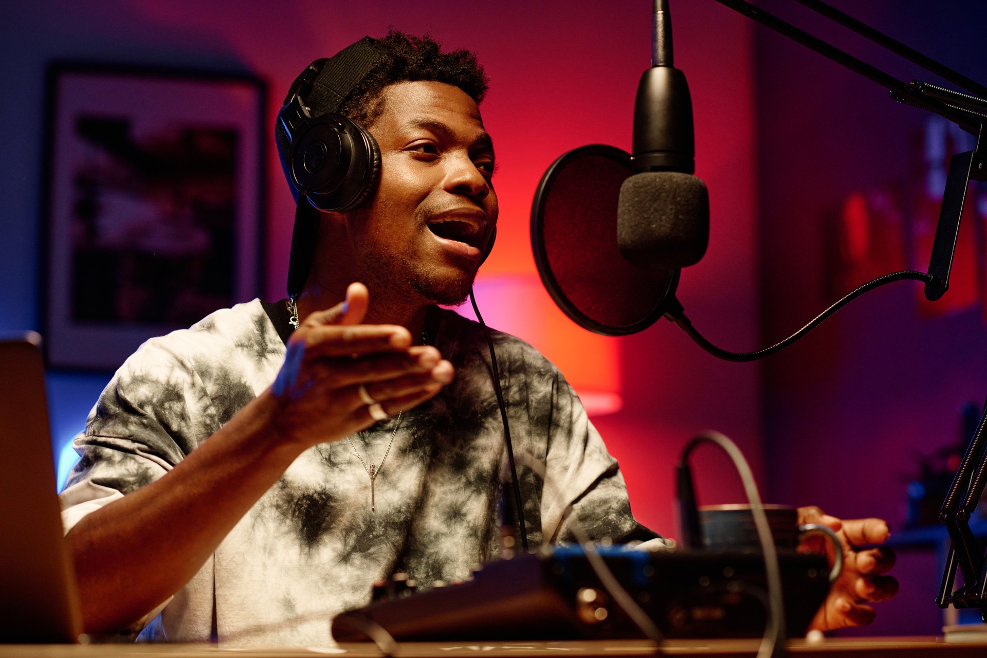 Young male radio presenter in headphones talking in microphone